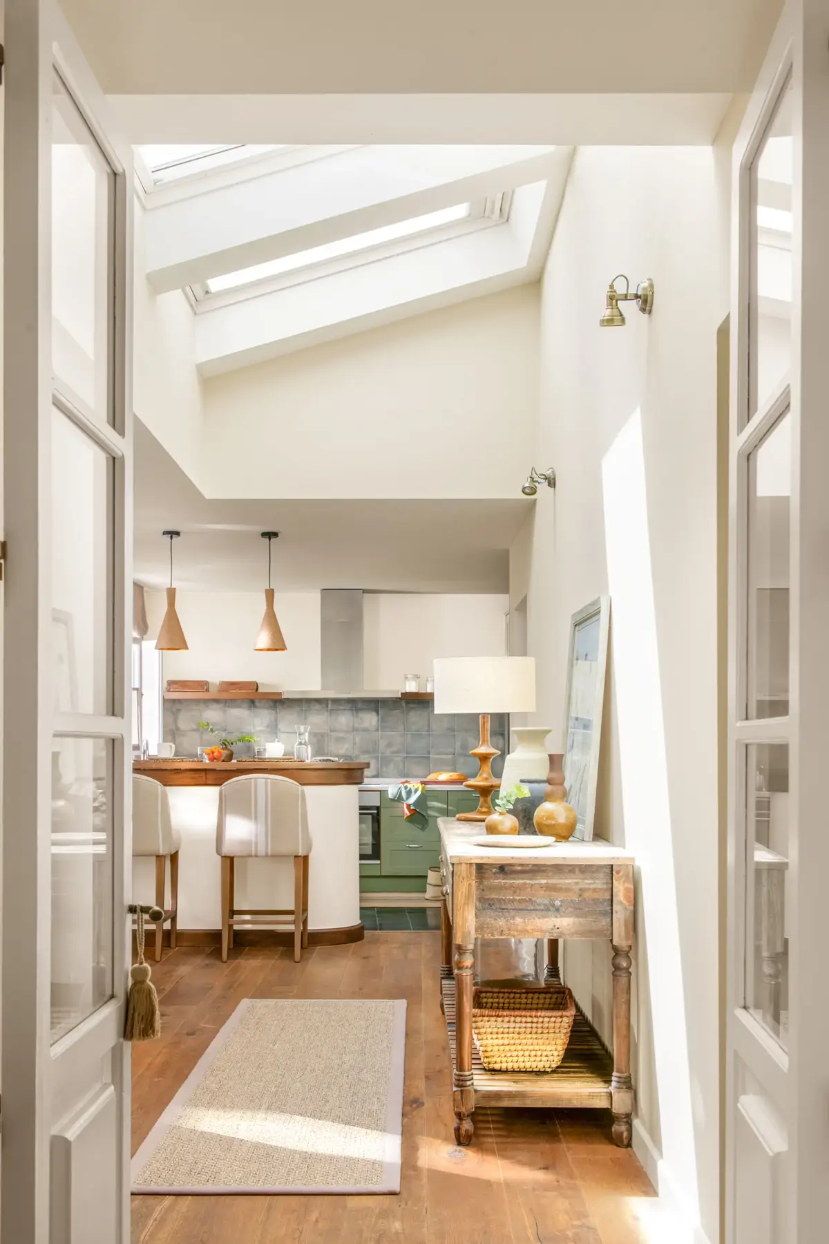 Cuisine semi-ouverte lumineuse avec fenêtre de toit et portes vitrées