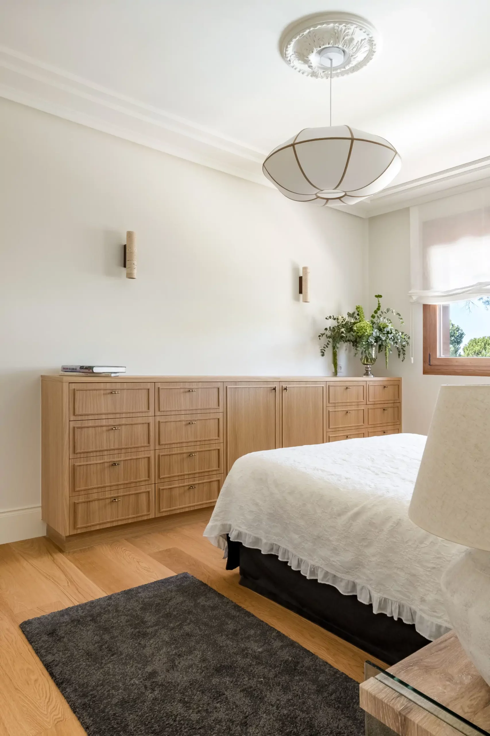 Appliques murales installées au-dessus d'une console en bois dans une chambre