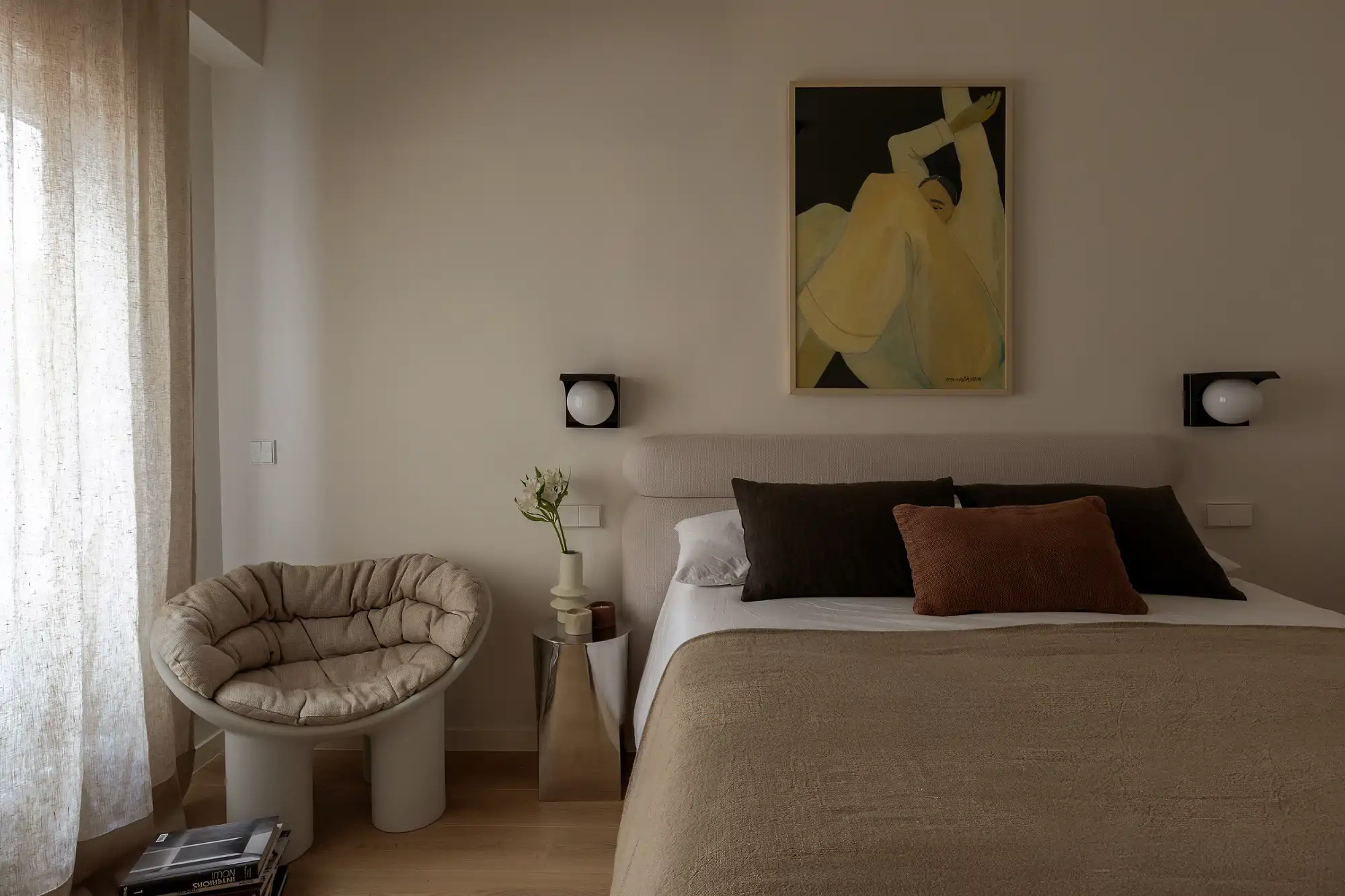 Chambre design avec appliques murales originales, fauteuil et tableau décoratif