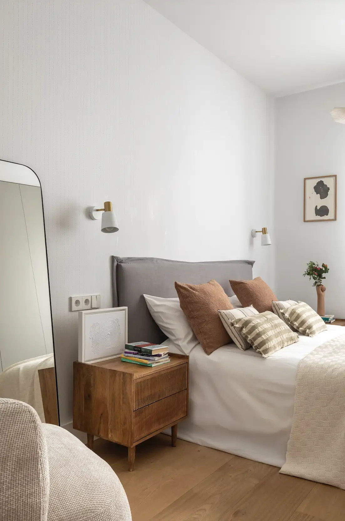 Appliques murales blanc mat et laiton doré dans une chambre aux tons neutres